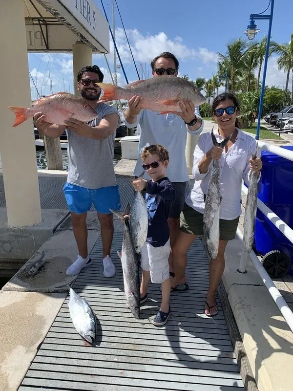 Cooler of mixed Miami catch including snapper, mahi, and jacks from a charter