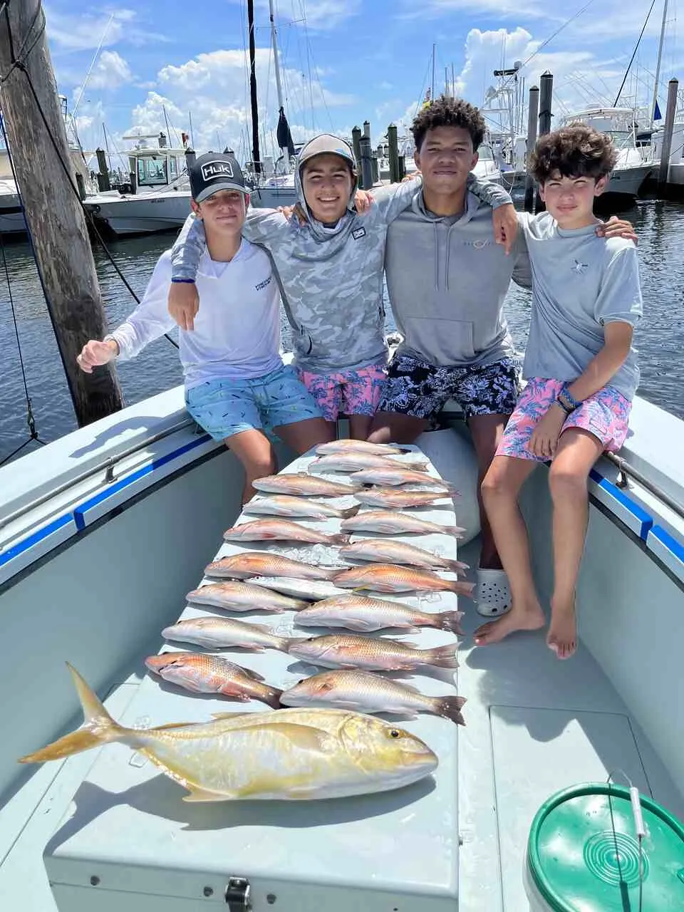 Angler holding a snapper caught on a half-day Miami fishing charter near shore