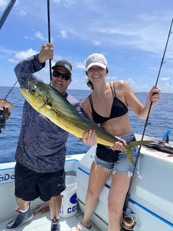 Anglers on a Miami fishing charter catching sailfish and mahi offshore